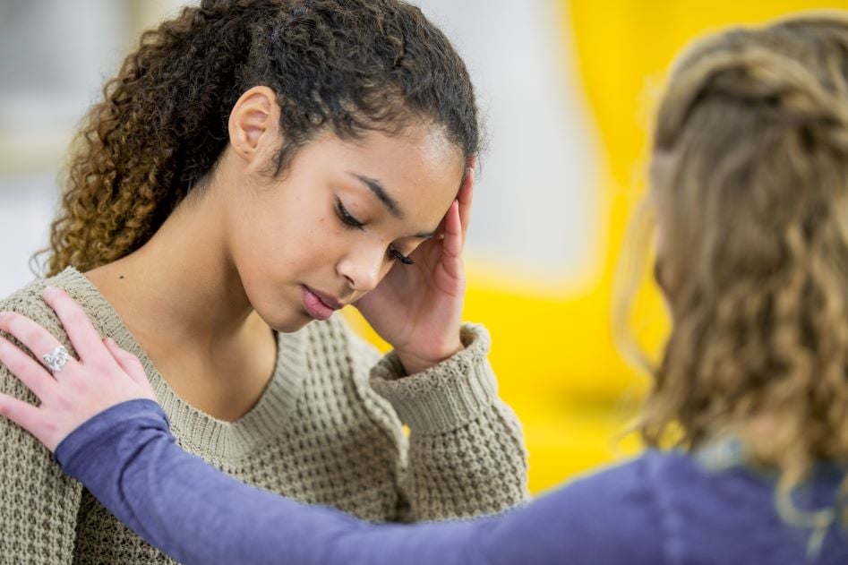 black-female-teen-young-adult-friend-mixed-race-hand-on-shoulder-counseling-support-sad-FatCamera-Getty Images-840293800_4494x2996